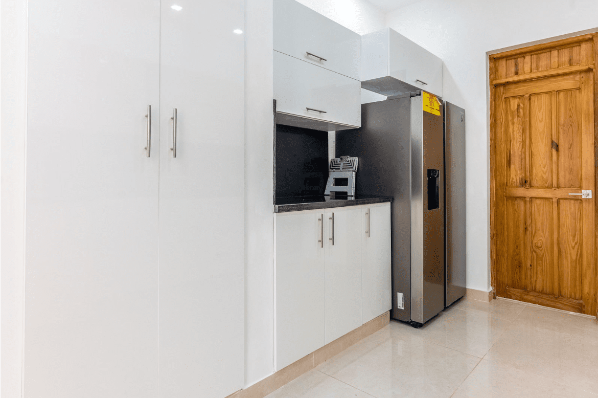 buyDRproperty Modern kitchen in a Gorgeous 5 Bedroom Villa with white cabinets and stainless steel appliances. Sosua Real Estate