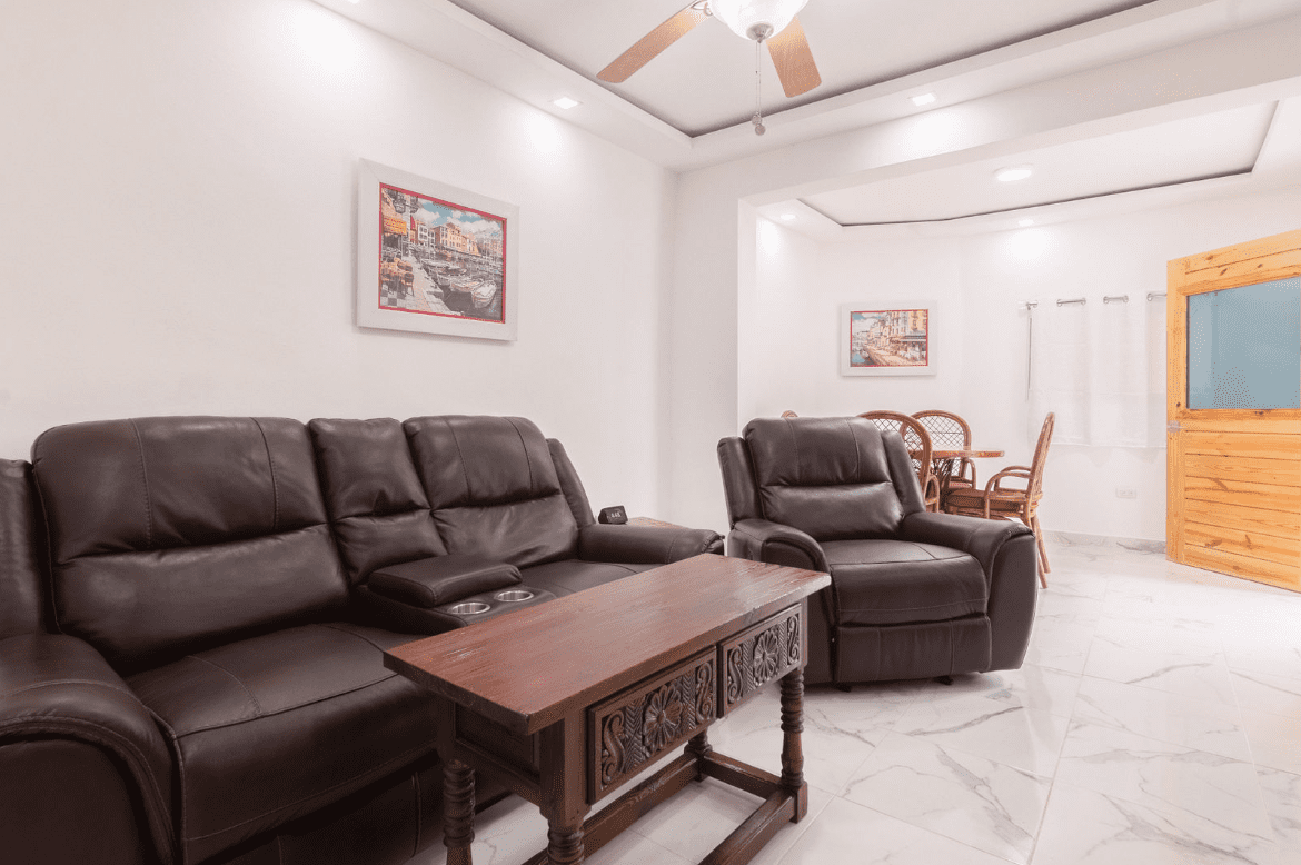 buyDRproperty Living room in a gorgeous 5 bedroom villa with brown leather furniture and artwork. Sosua Real Estate