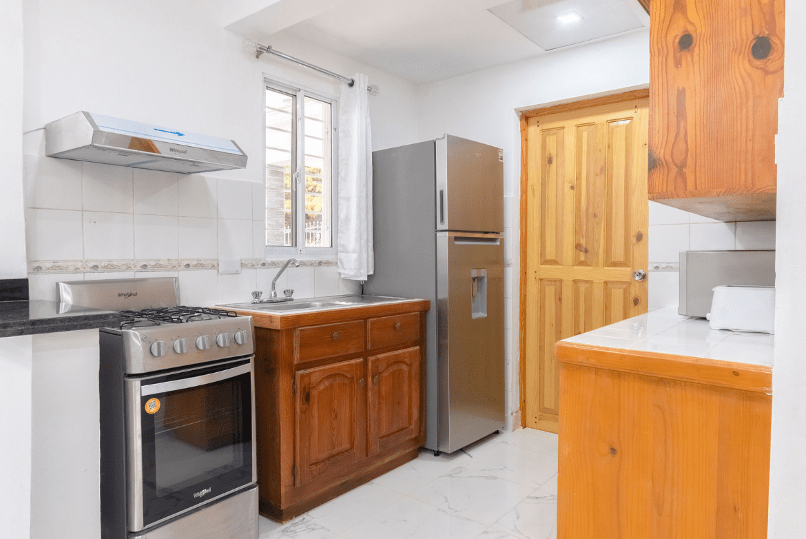 buyDRproperty Small kitchen with stainless steel appliances and wooden cabinets. Gorgeous 5 Bedroom Villa. Sosua Real Estate