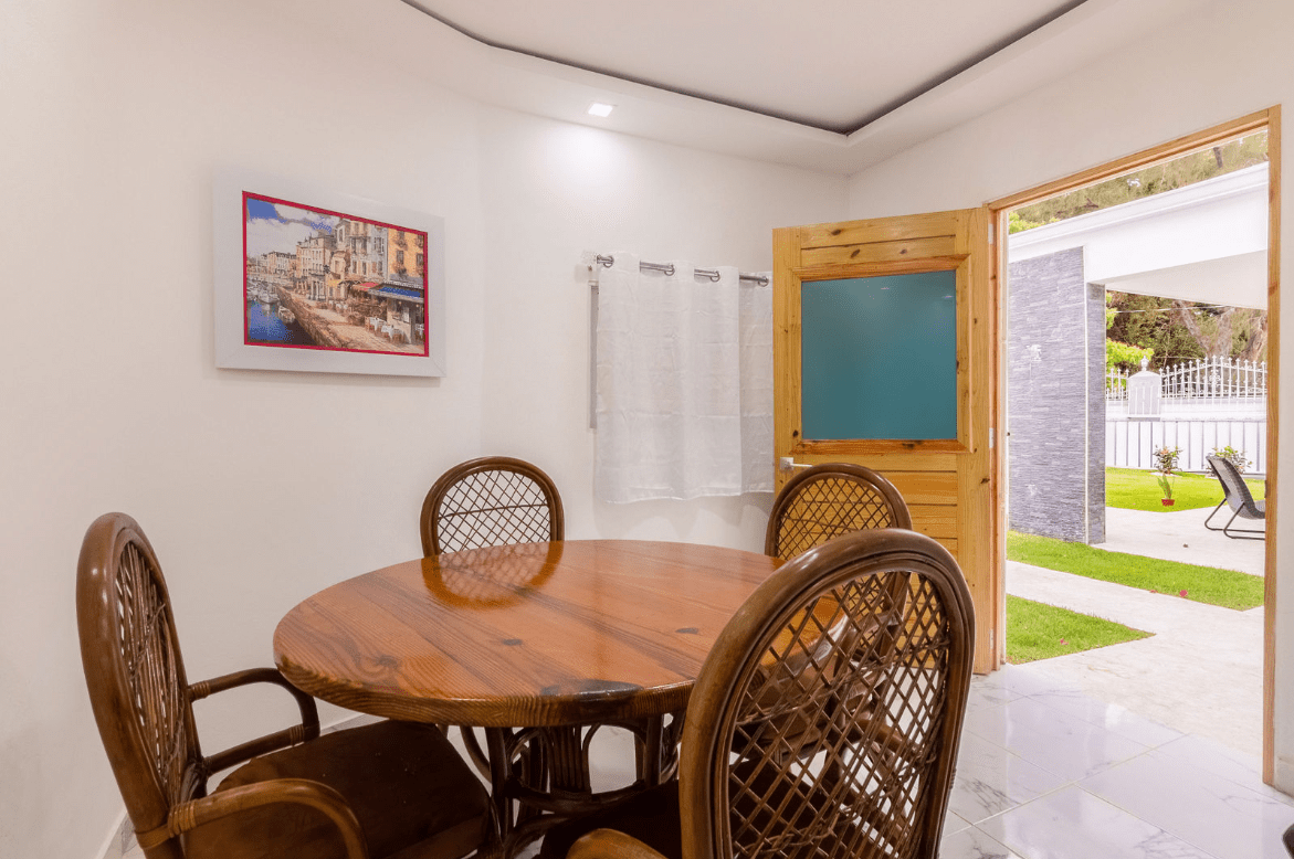 buyDRproperty Dining area with round wooden table and wicker chairs in a gorgeous 5 bedroom villa. Sosua Real Estate