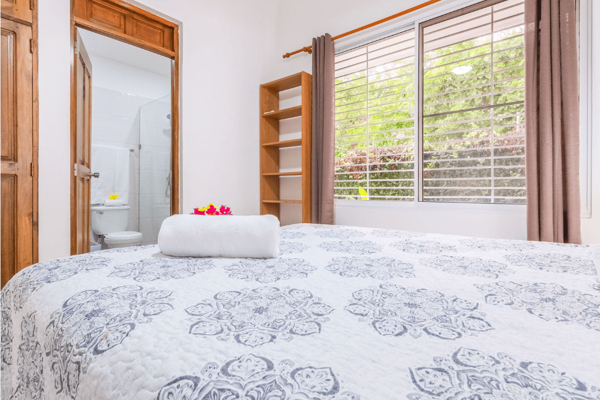 buyDRproperty Bedroom in a gorgeous 5 bedroom villa with a rolled towel and flowers on the bed. Sosua Real Estate