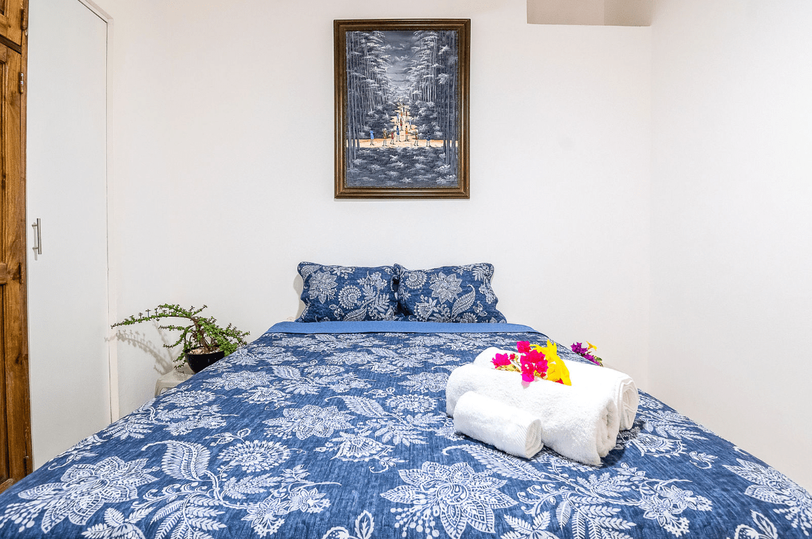buyDRproperty Cozy bedroom with blue patterned bedding, towels, and flowers in a Gorgeous 5 Bedroom Villa Sosua Real Estate