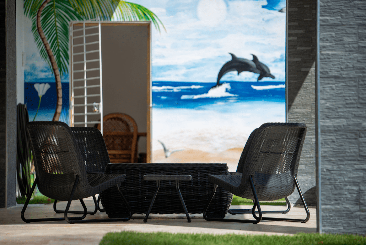 buyDRproperty Outdoor seating area at a Gorgeous 5 Bedroom Villa, featuring a beach mural. Sosua Real Estate