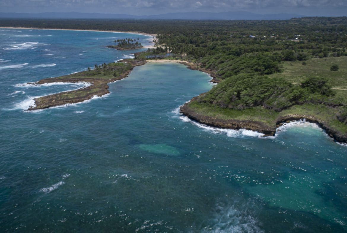 buyDRproperty Aerial view of Oceanfront Development Property with Marina Potential on a turquoise coast. Sosua Real Estate