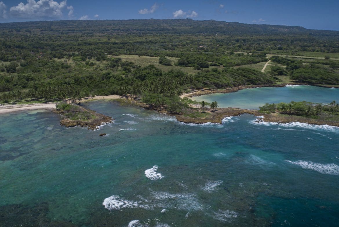 buyDRproperty Aerial view of oceanfront development property with potential marina, showcasing a beautiful coastline. Sosua Real Estate