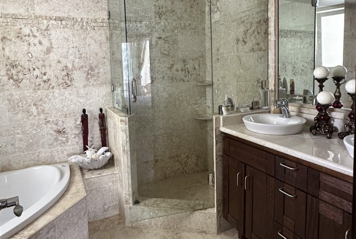buyDRproperty Luxury bathroom with shower, sink, and bathtub in an oceanfront condo for sale. Sosua Real Estate