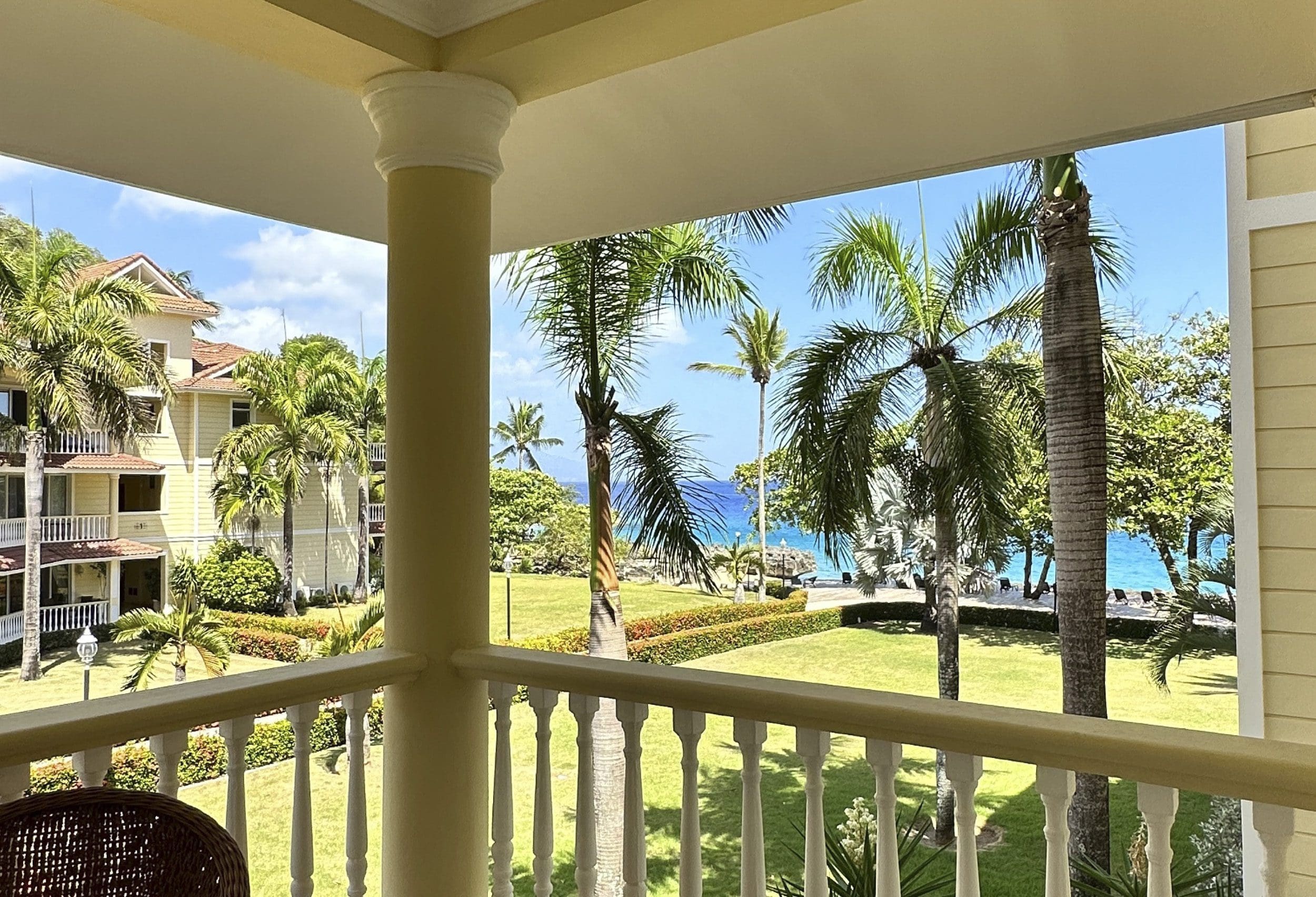 buyDRproperty Ocean view from a condo balcony in Sosua, with palm trees and the ocean. Sosua Real Estate