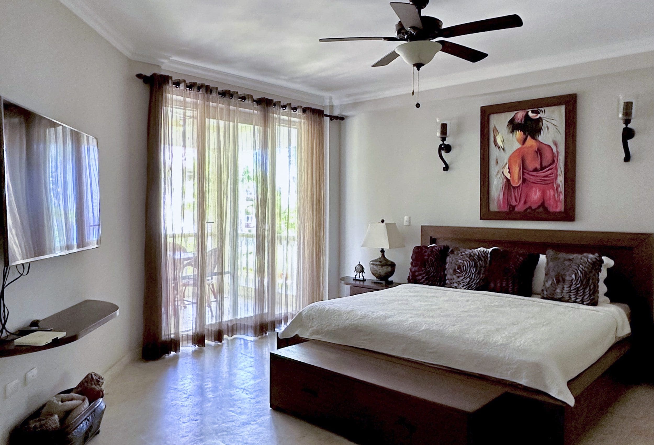 buyDRproperty Bedroom interior with a bed, TV, and sheer curtains. Sosua Real Estate