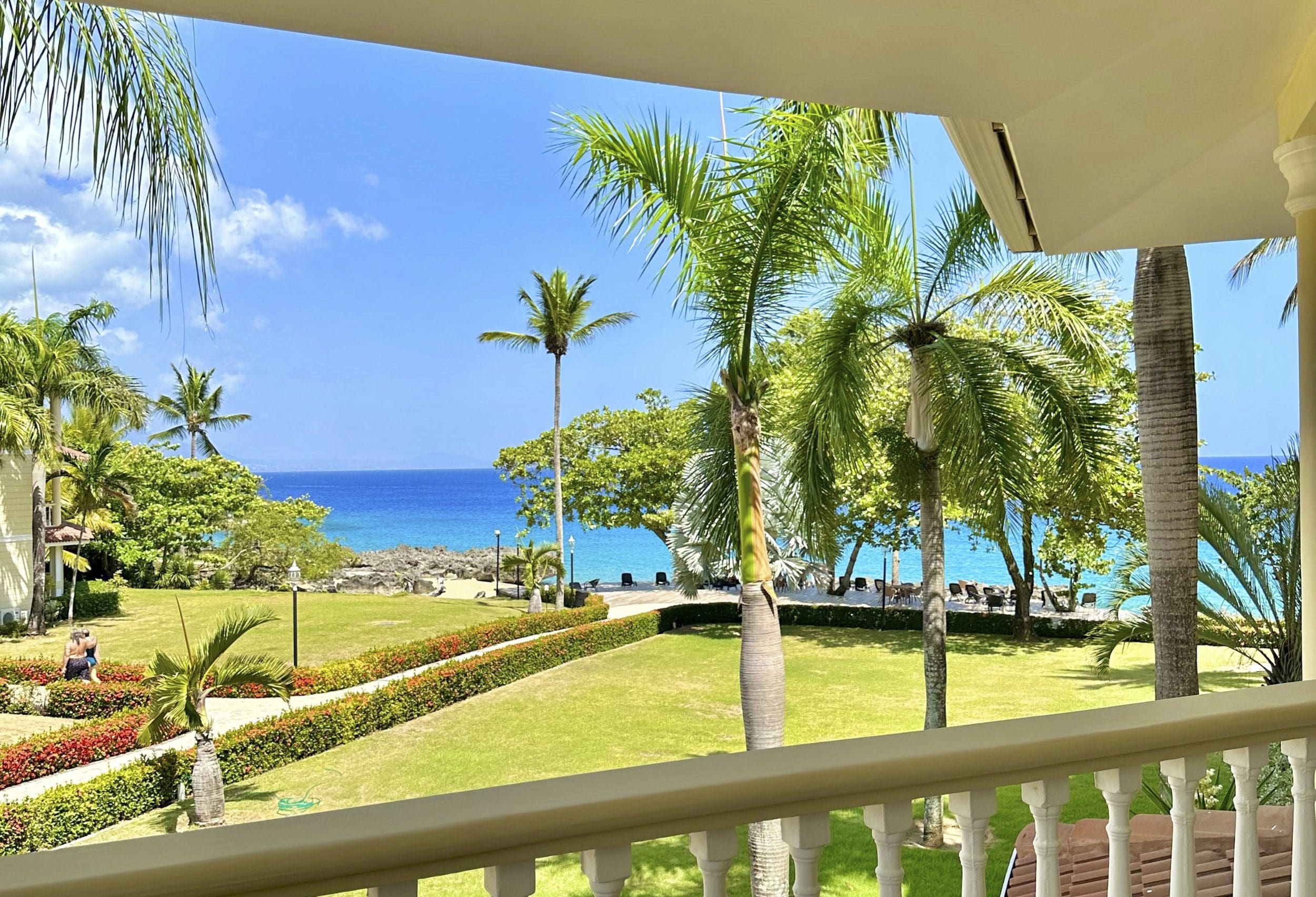 buyDRproperty Ocean view from a balcony in Sosua, Dominican Republic; palm trees and turquoise water. Sosua Real Estate