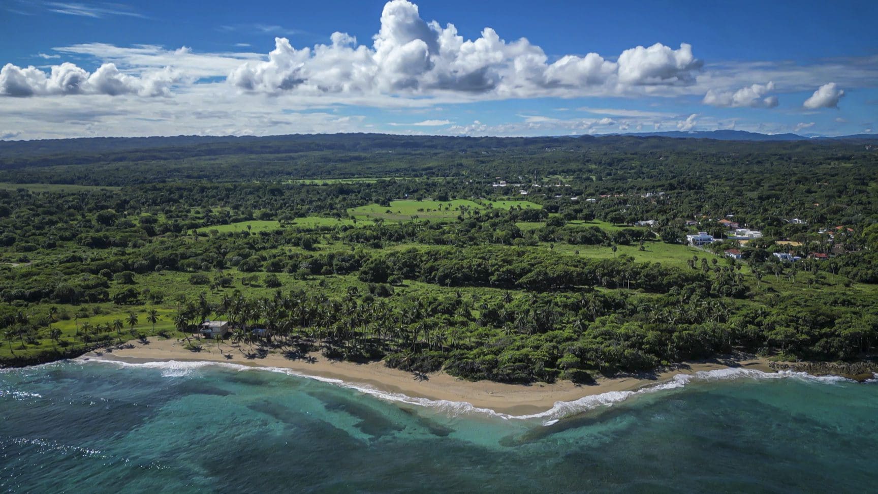 buyDRproperty Aerial view of stunning oceanfront development property with turquoise water and lush green landscape Sosua Real Estate