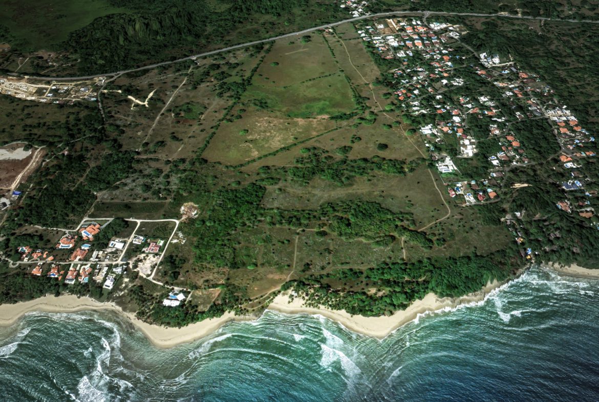 buyDRproperty Aerial view of stunning oceanfront development property with beach and homes. Sosua Real Estate