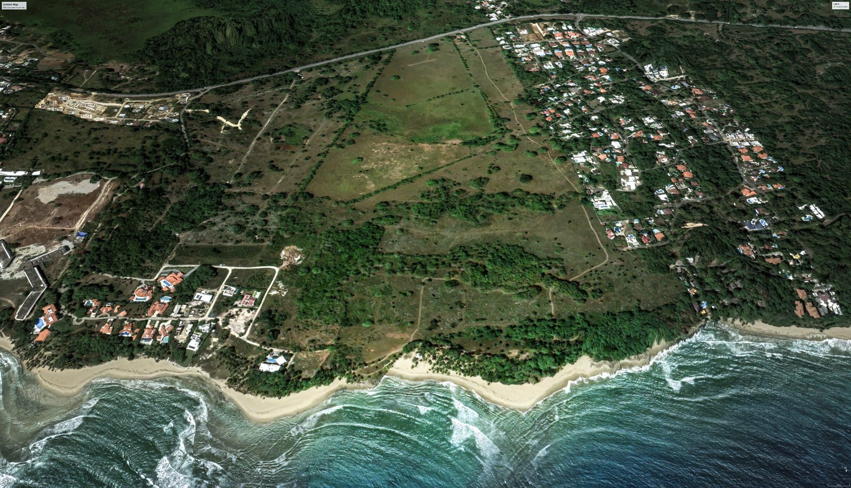 buyDRproperty Aerial view of stunning oceanfront development property with beach and homes. Sosua Real Estate