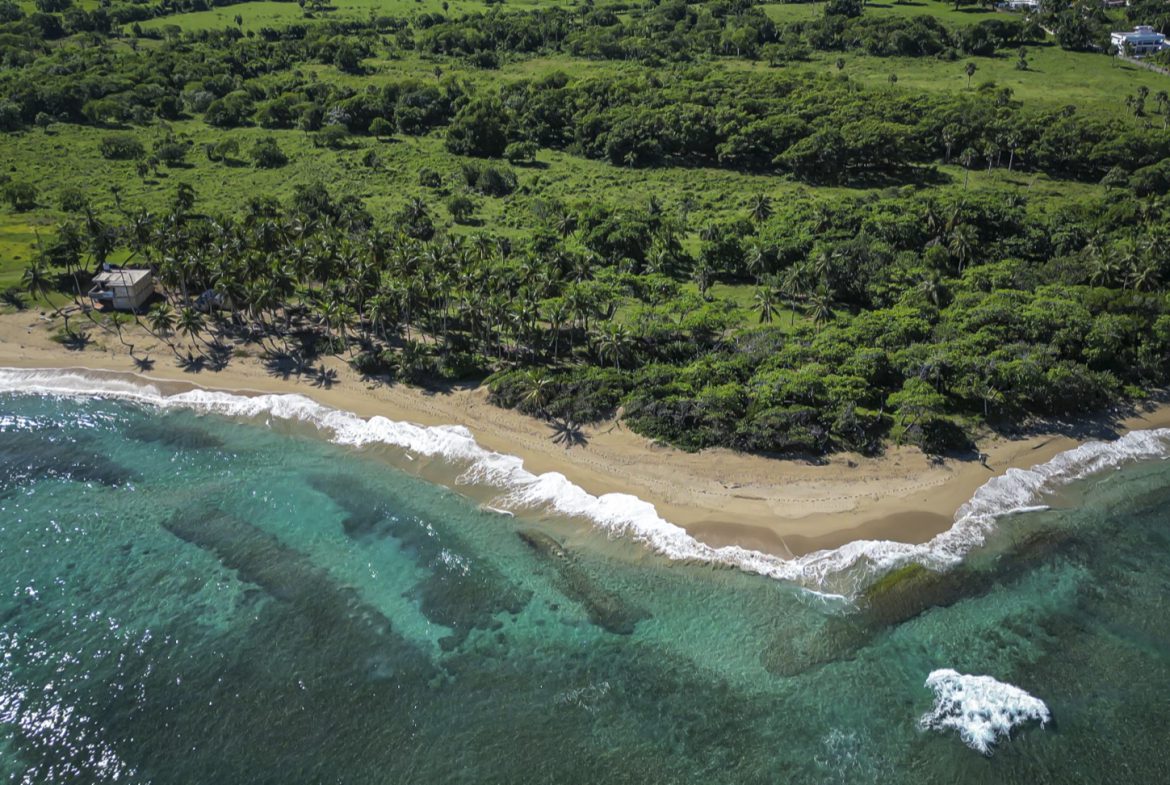 buyDRproperty Aerial view of stunning oceanfront development property with turquoise water and beach. Sosua Real Estate