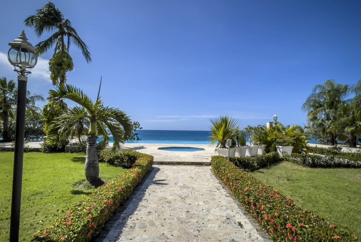 buyDRproperty Oceanfront view from a pathway leading to a pool, Sosua, Dominican Republic. Sosua Real Estate