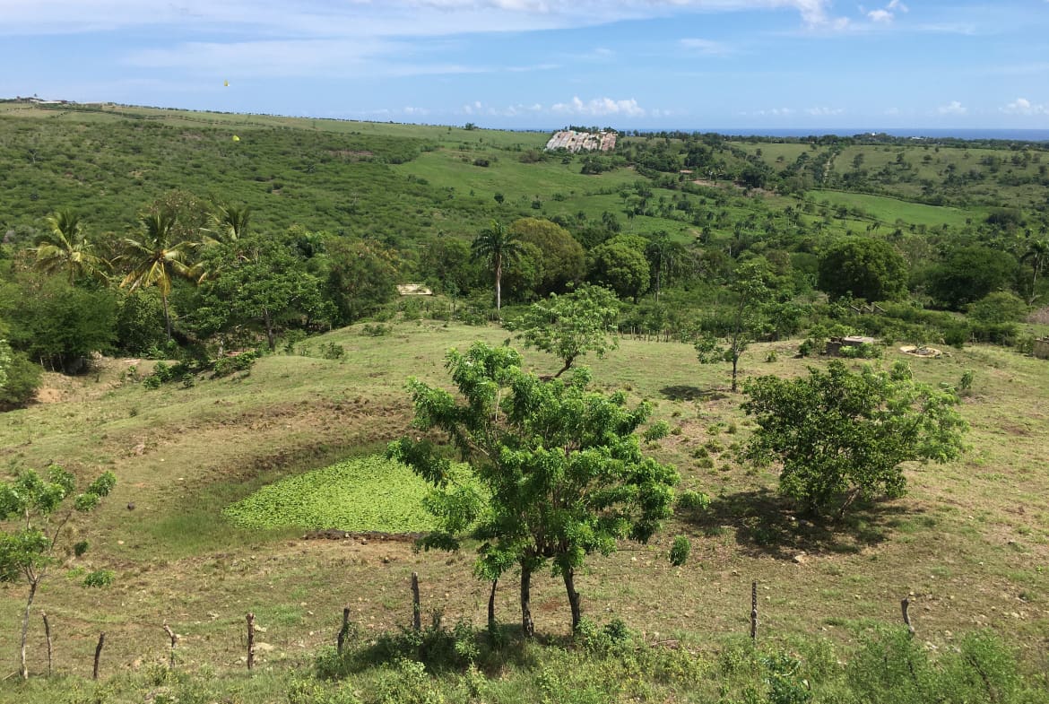 buyDRproperty Expansive green development property with lush landscapes under a blue sky Sosua Real Estate
