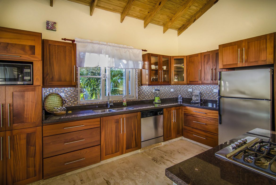 buyDRproperty Elegant wooden kitchen with stainless steel appliances, a villa for sale in the Community of Terramar. Sosua Real Estate