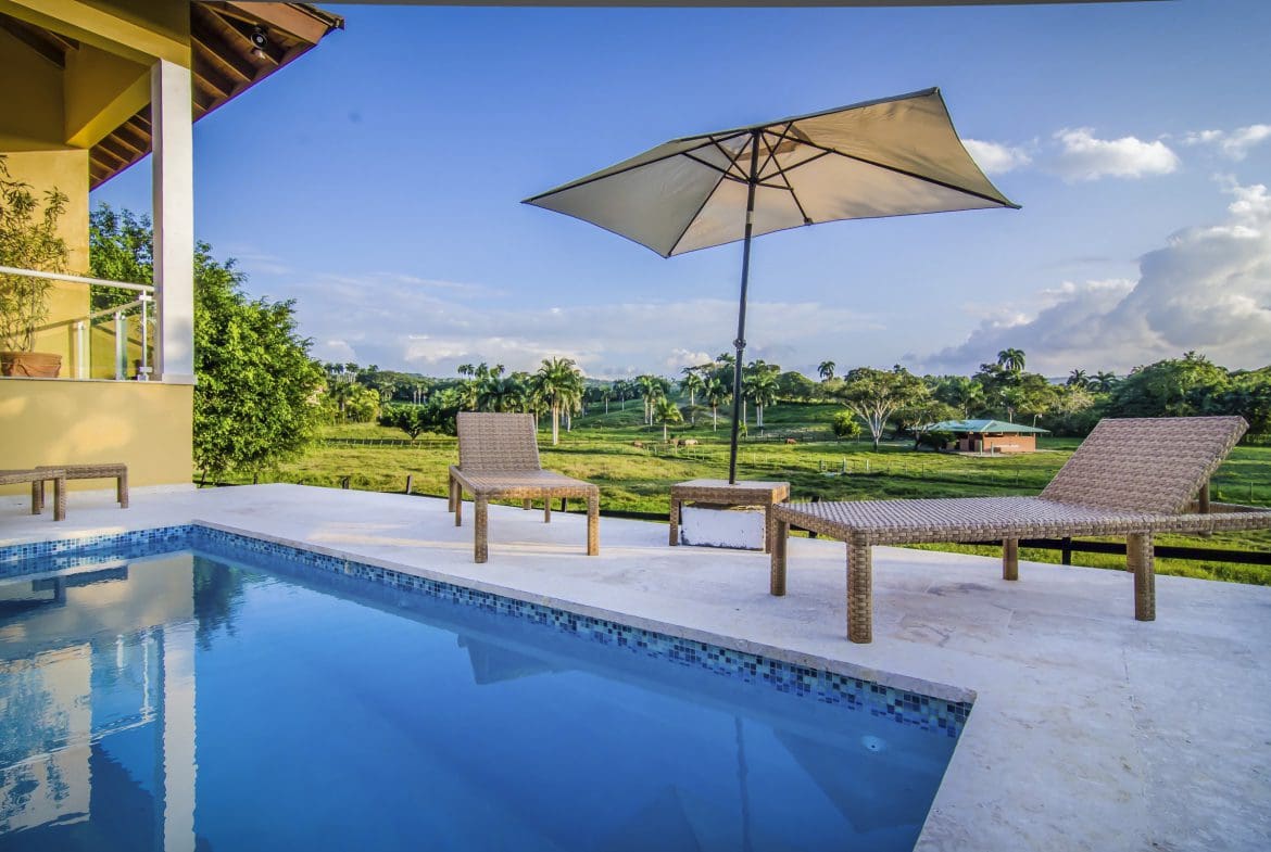 buyDRproperty Luxury villa for sale in the Community of Terramar with swimming pool and relaxing outdoor seating. Sosua Real Estate