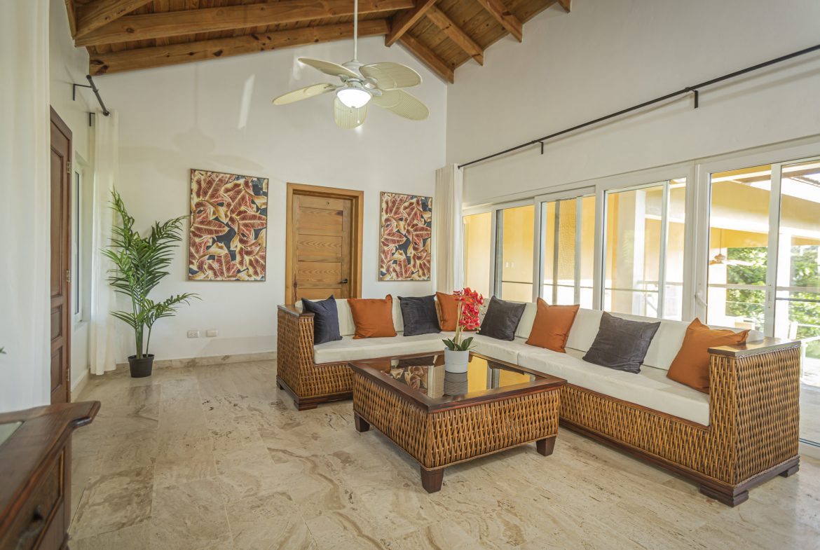 buyDRproperty Living room in a villa for sale in the Community of Terramar with wicker furniture and colorful cushions. Sosua Real Estate