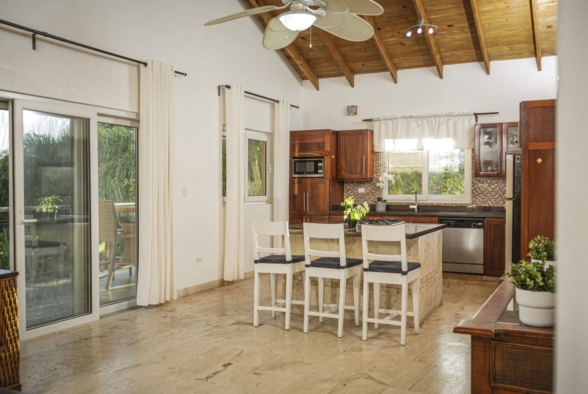 buyDRproperty Kitchen interior of a villa for sale in Terramar community with breakfast bar and outdoor view. Sosua Real Estate