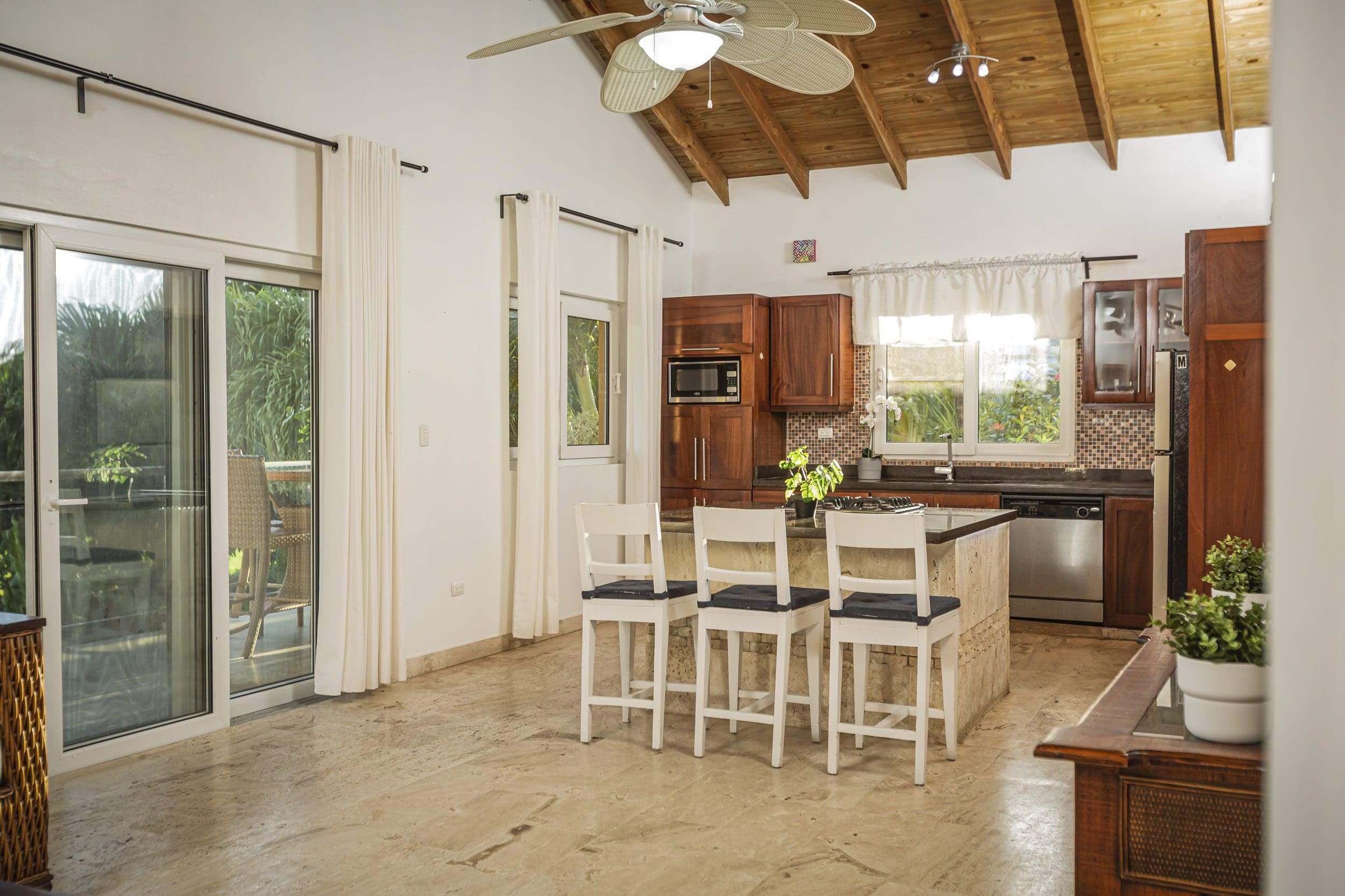 buyDRproperty Kitchen interior of a villa for sale in Terramar community with breakfast bar and outdoor view. Sosua Real Estate