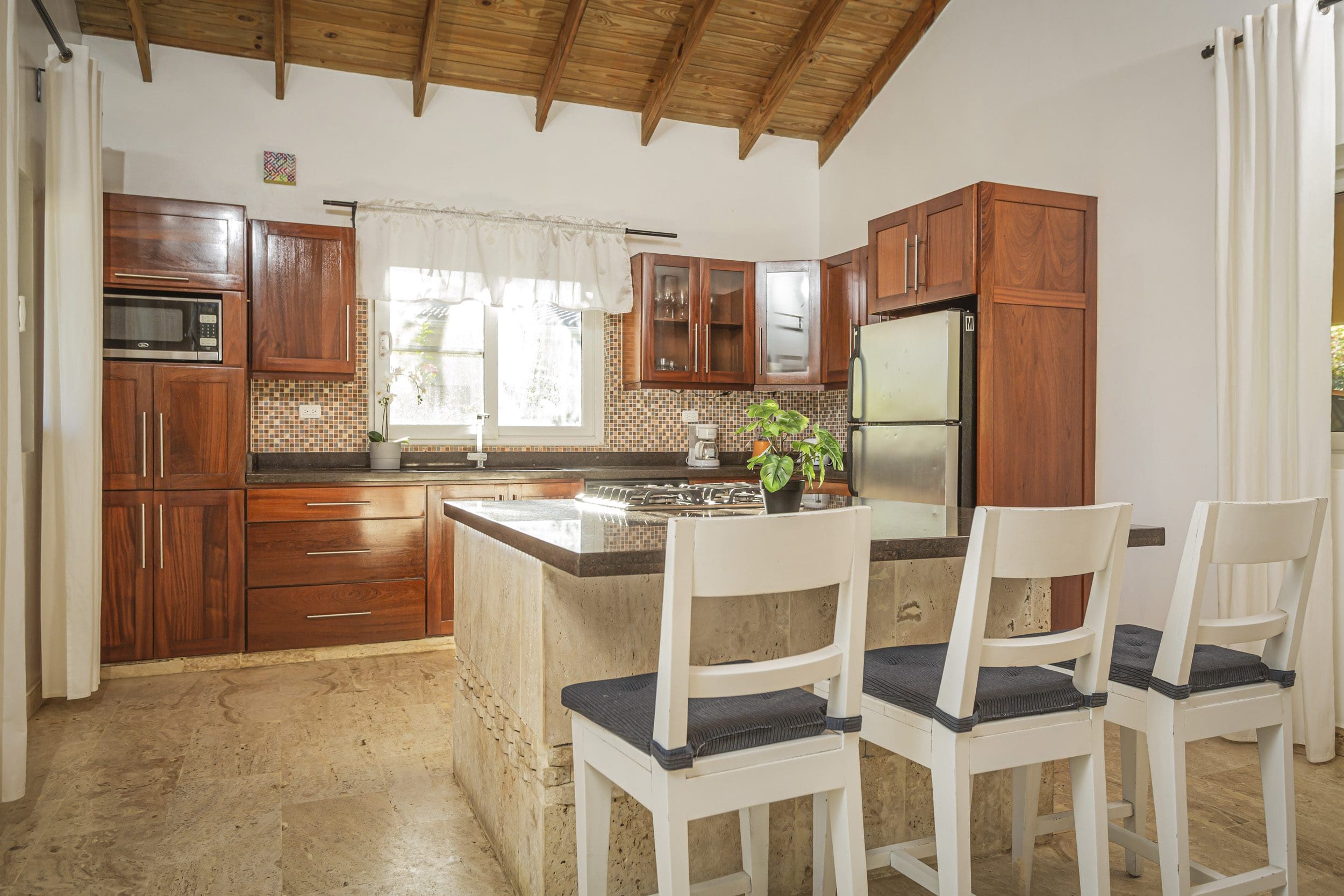buyDRproperty Stylish kitchen with wooden cabinets and a breakfast bar. This Villa For Sale is in the Community Of Terramar. Sosua Real Estate