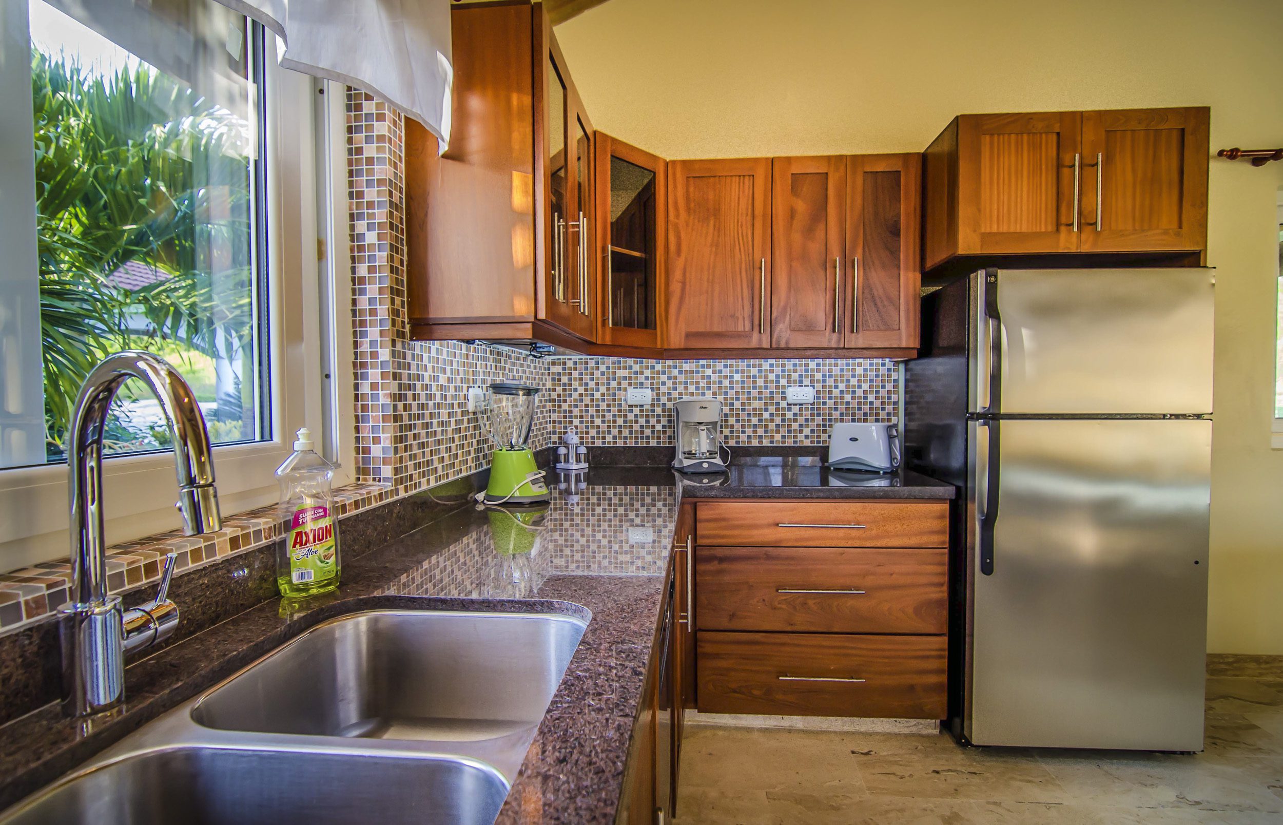 buyDRproperty Kitchen in a Villa For Sale in the Community of Terramar with wooden cabinets and stainless steel appliances. Sosua Real Estate