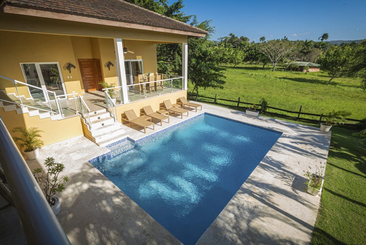 buyDRproperty Luxury villa for sale in Terramar community with a pool and sun loungers. Sosua Real Estate