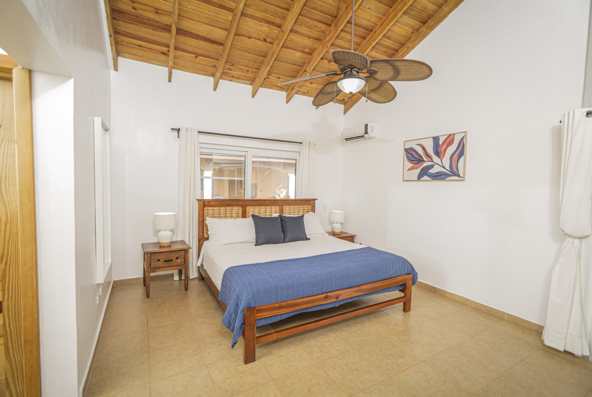 buyDRproperty Bedroom in a Villa For Sale in the Community of Terramar with wooden ceiling and bed. Sosua Real Estate