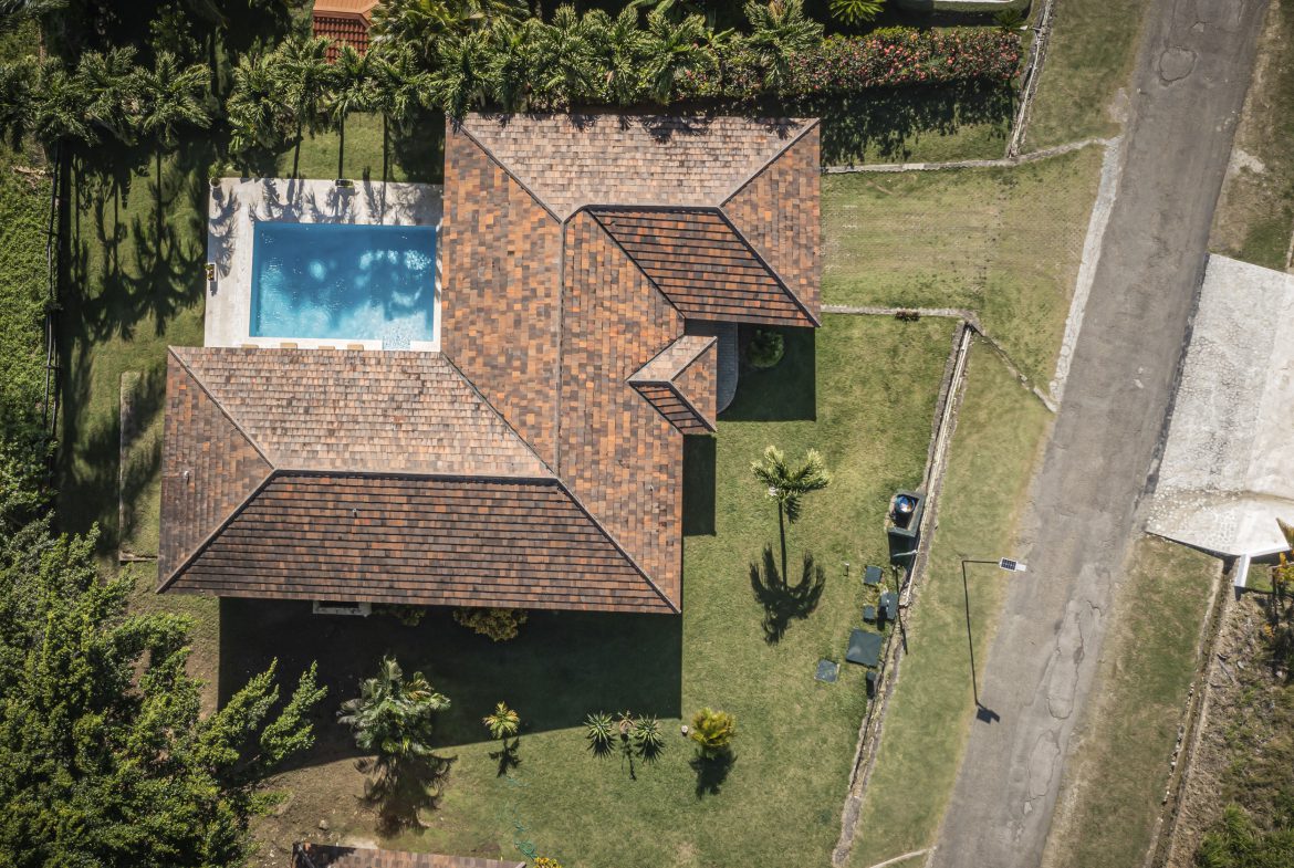 buyDRproperty Aerial view of a villa for sale in the Community of Terramar with a pool and lush landscaping. Sosua Real Estate