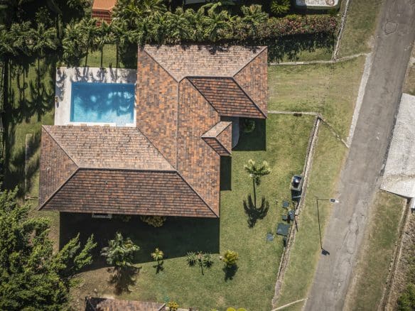 buyDRproperty Aerial view of a villa for sale in the Community of Terramar with a pool and lush landscaping. Sosua Real Estate