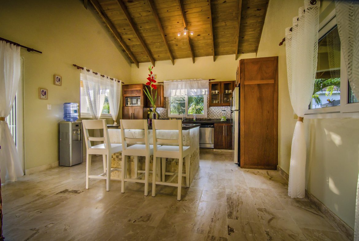 buyDRproperty Bright kitchen in a Villa For Sale in the Community of Terramar with white chairs and wooden ceiling. Sosua Real Estate