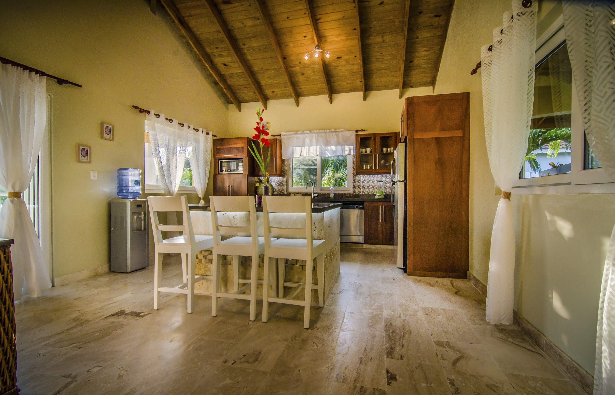 buyDRproperty Bright kitchen in a Villa For Sale in the Community of Terramar with white chairs and wooden ceiling. Sosua Real Estate