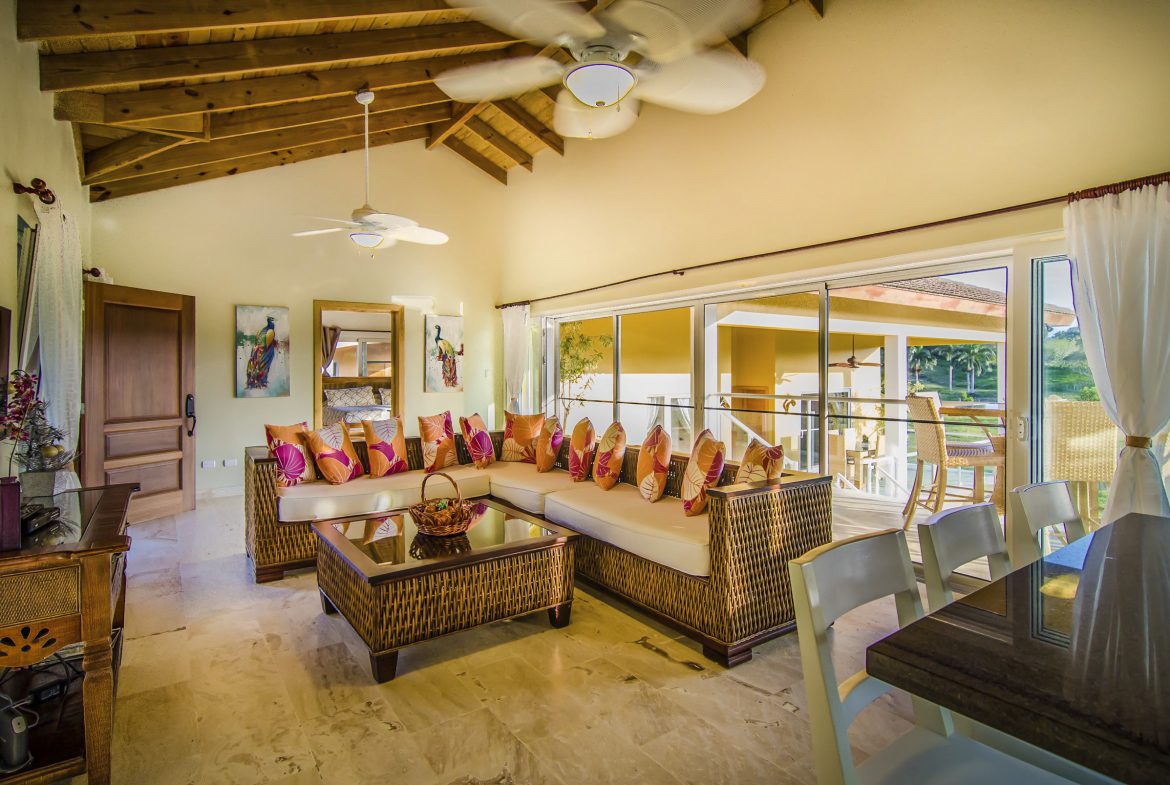 buyDRproperty Luxury living room in a Villa For Sale in the Community of Terramar with wicker furniture and outdoor access. Sosua Real Estate