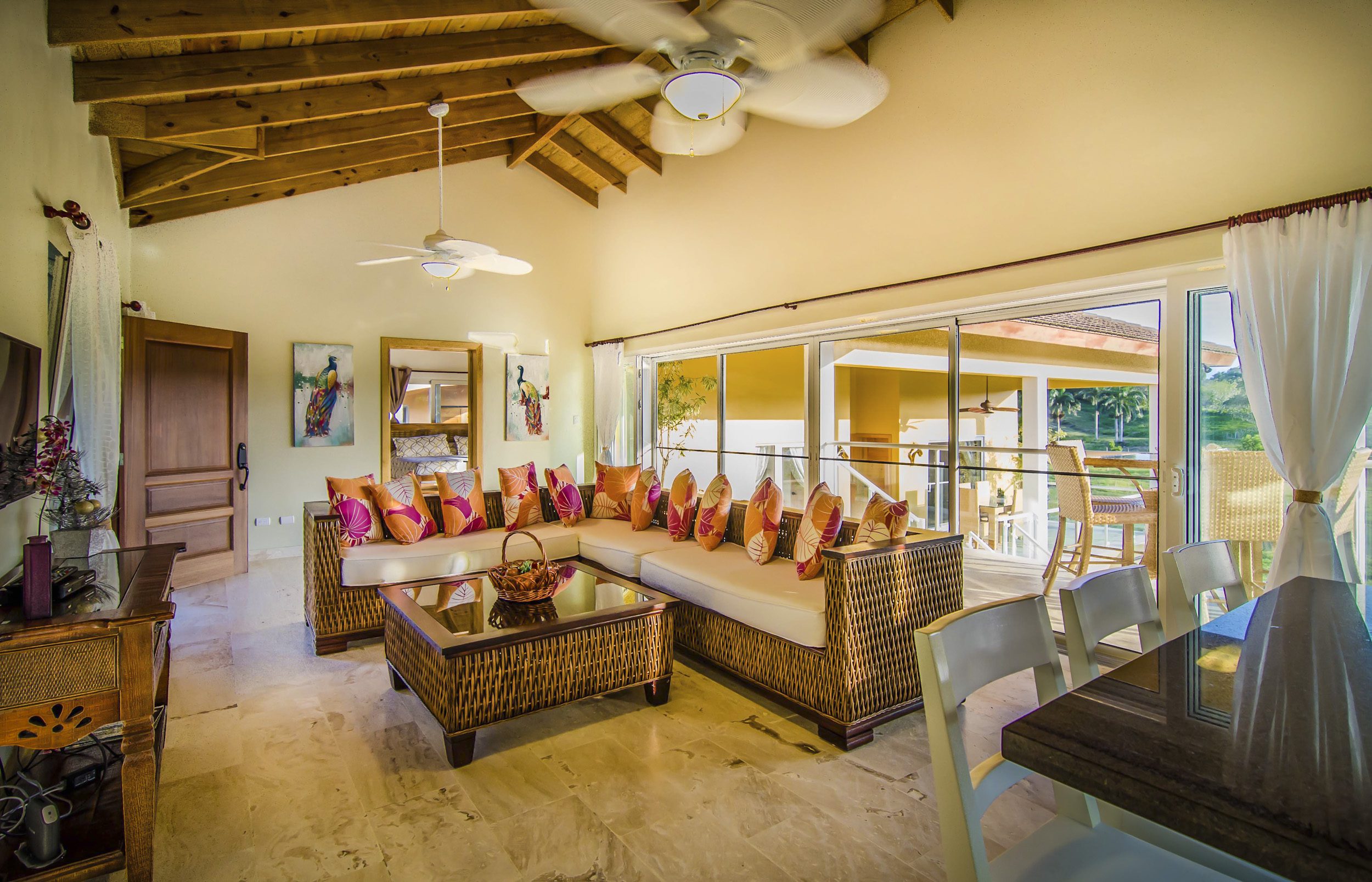 buyDRproperty Luxury living room in a Villa For Sale in the Community of Terramar with wicker furniture and outdoor access. Sosua Real Estate