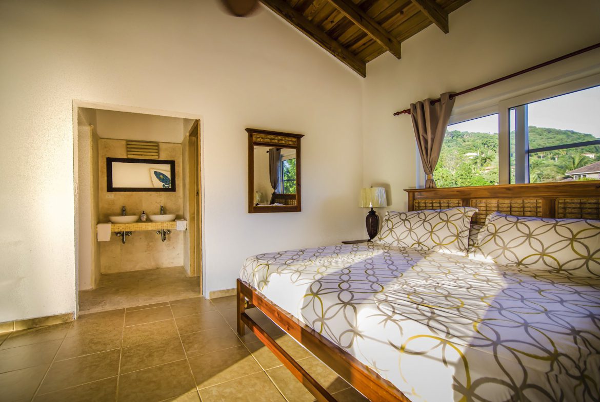 buyDRproperty Bedroom in a Villa For Sale in the Community of Terramar, featuring a bed and a view. Sosua Real Estate