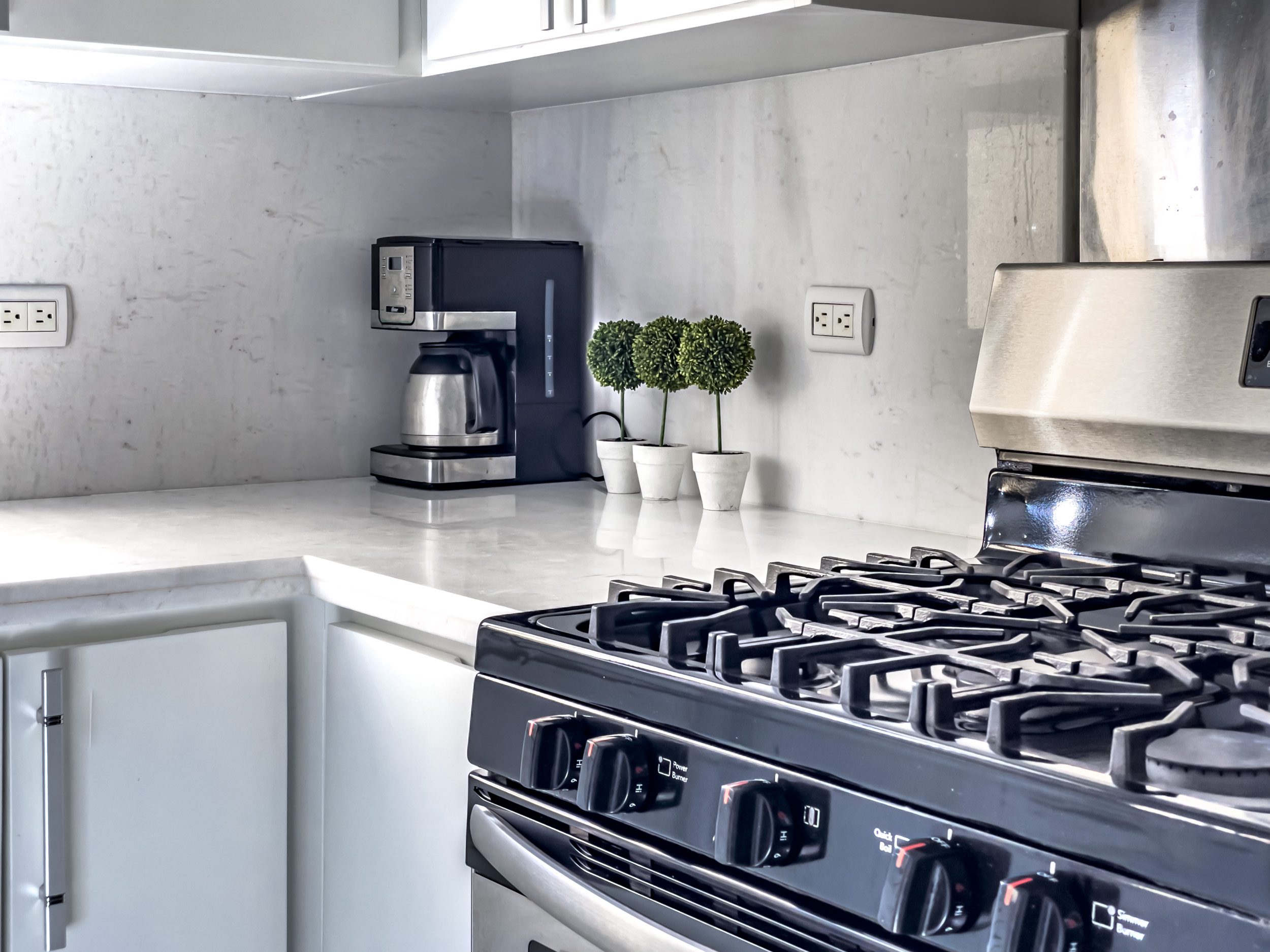 buyDRproperty Modern kitchen in a stunning 4 bedroom villa with white countertops and black stove. Sosua Real Estate