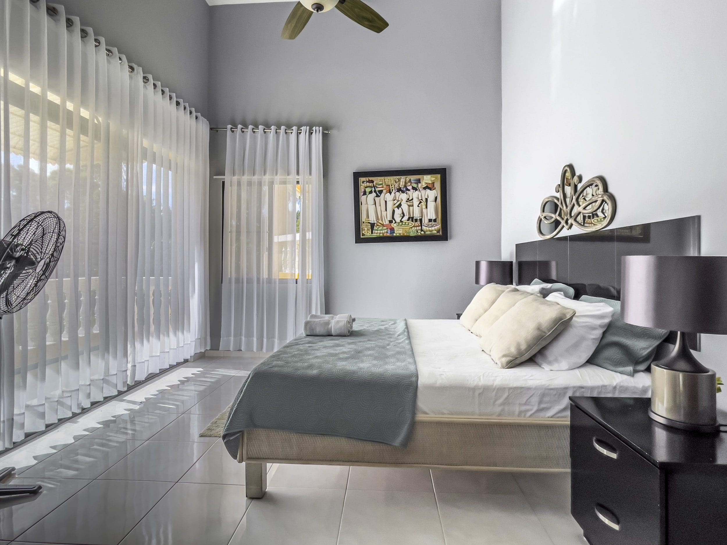 buyDRproperty Stunning 4 Bedroom Villa bedroom with bed, sheer curtains, and a ceiling fan Sosua Real Estate