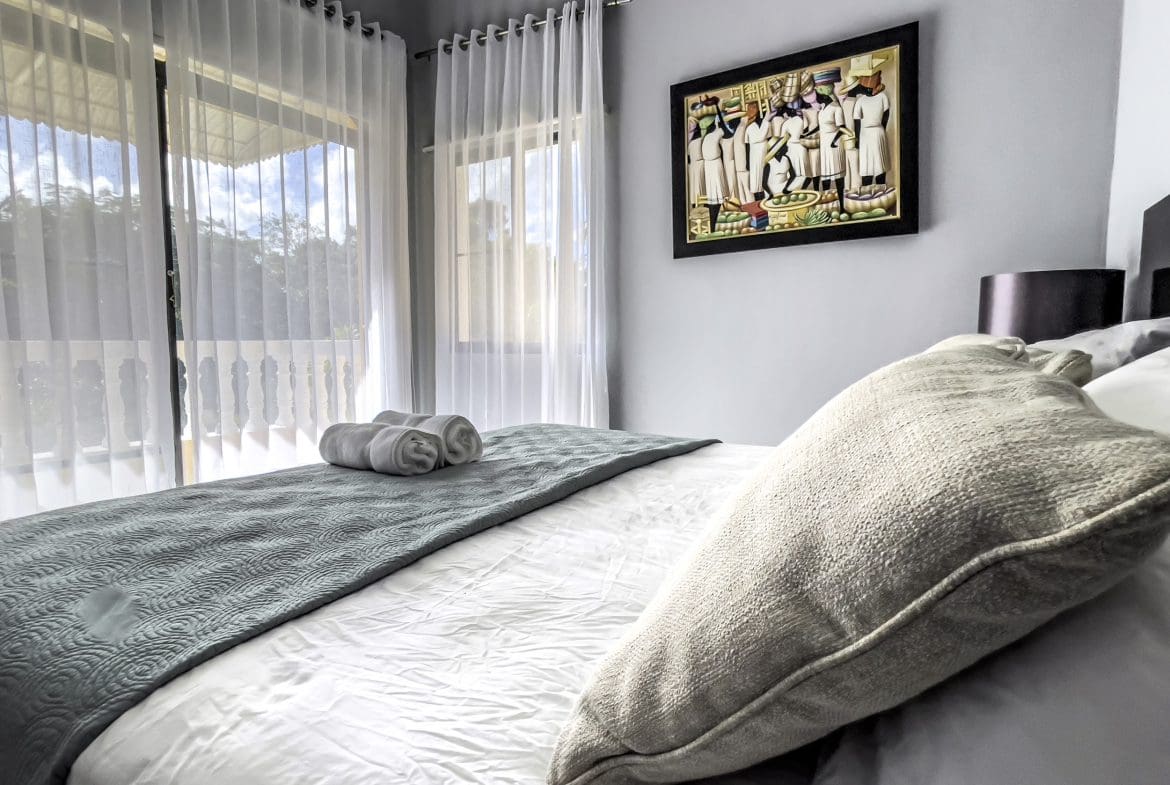 buyDRproperty Bedroom in a stunning 4 bedroom villa, with bed, curtains, and artwork. Sosua Real Estate