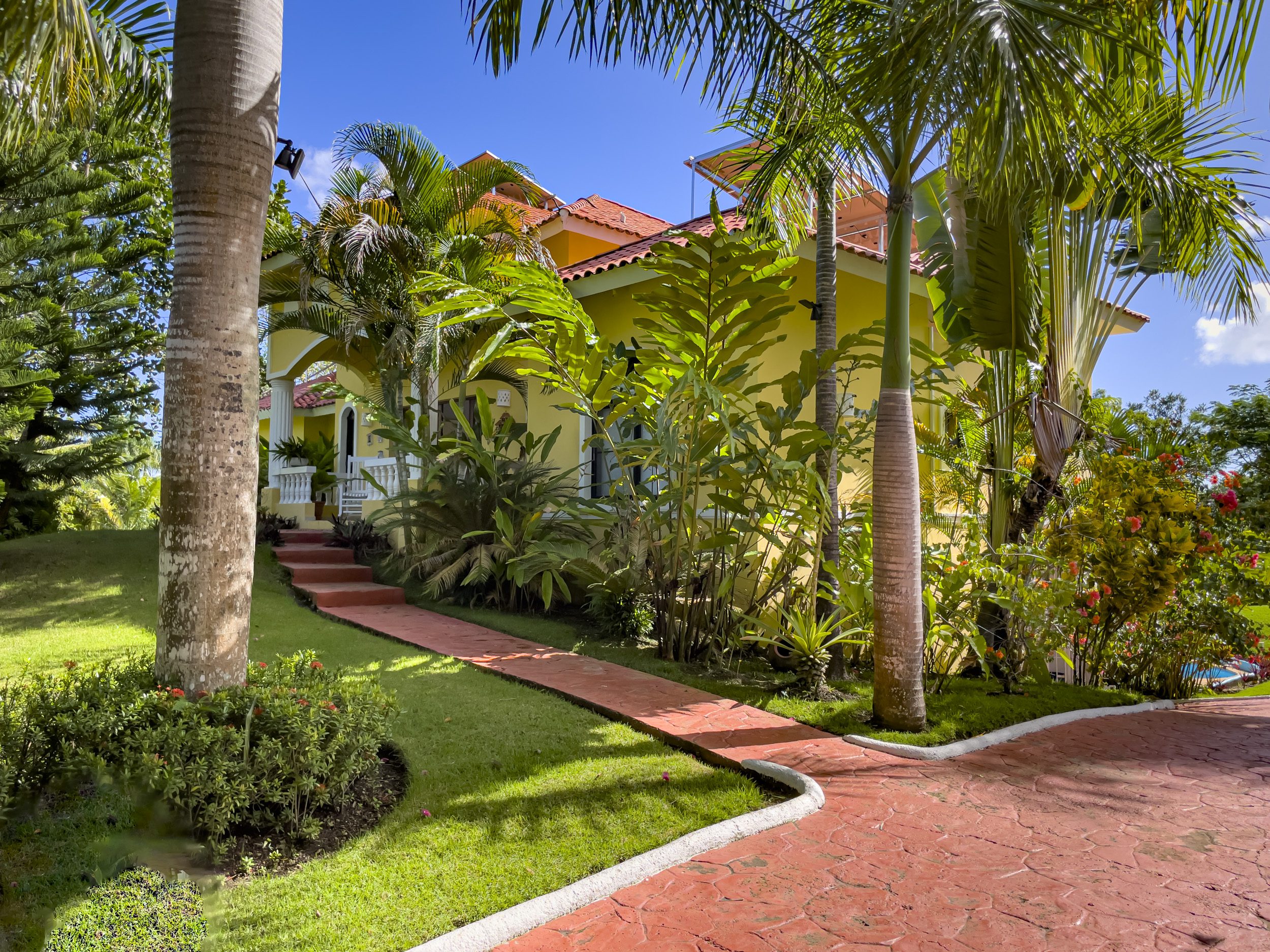 buyDRproperty Stunning 4 Bedroom Villa with tropical landscaping and red pathway Sosua Real Estate