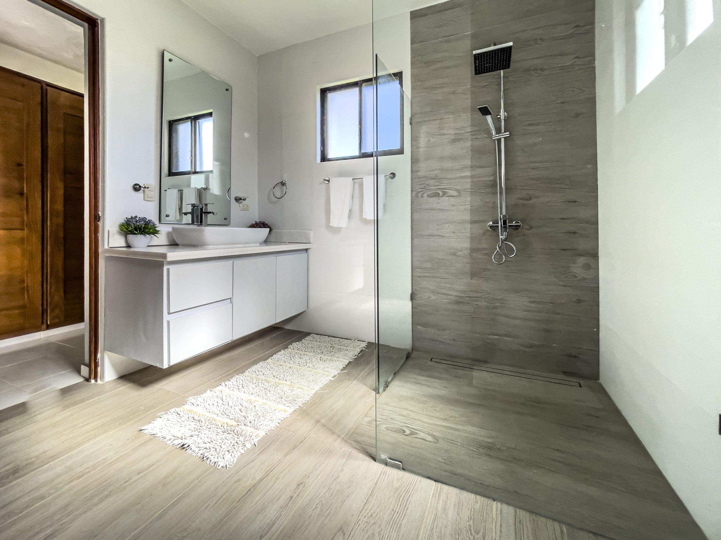 buyDRproperty Modern bathroom with walk-in shower and wood-look tiles in a stunning 4 bedroom villa. Sosua Real Estate