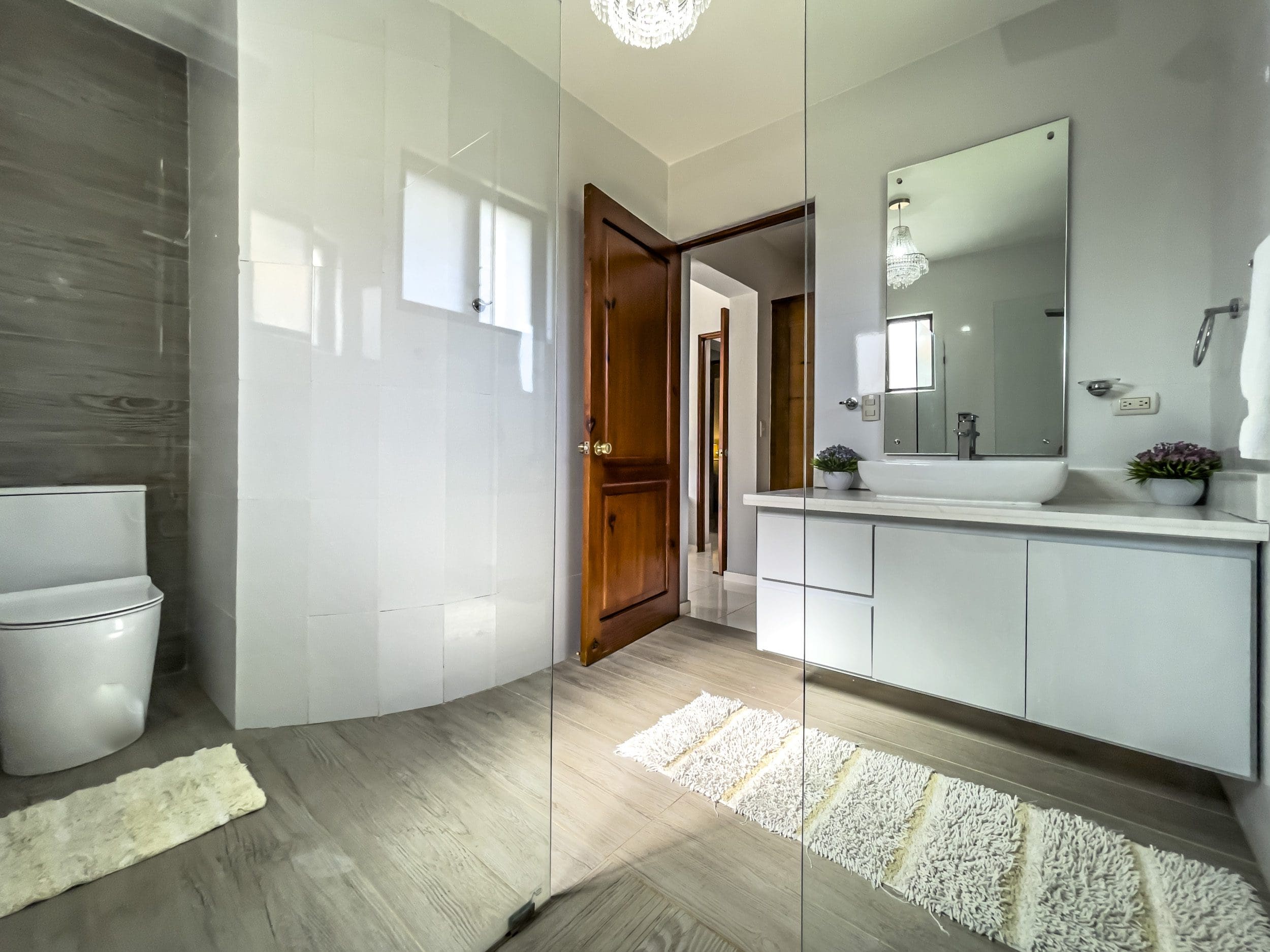 buyDRproperty Modern bathroom in a stunning 4 bedroom villa with white fixtures and glass shower. Sosua Real Estate