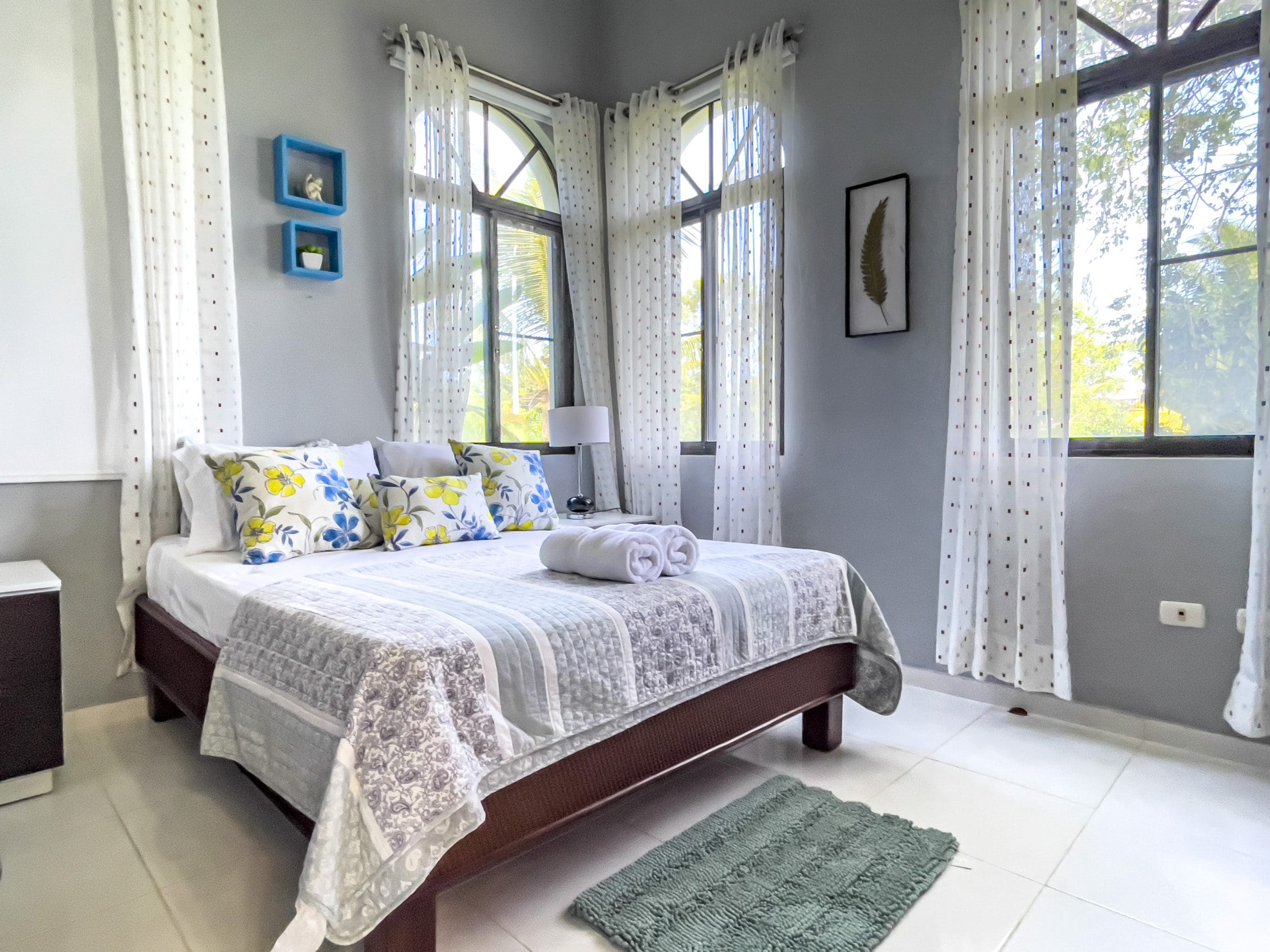 buyDRproperty Bedroom in a stunning 4 bedroom villa with floral pillows and sheer curtains. Sosua Real Estate