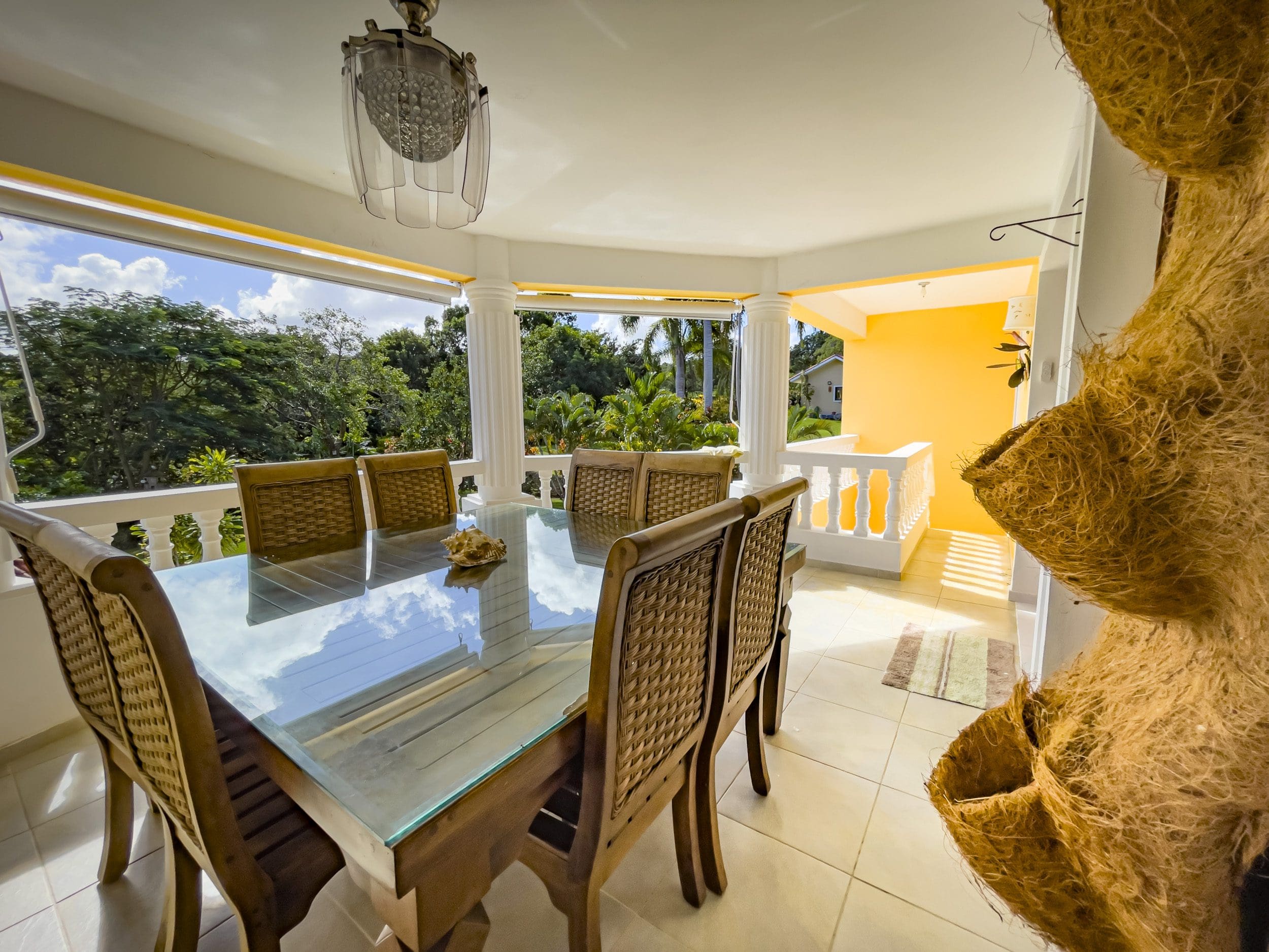 buyDRproperty Outdoor dining area of a stunning 4 bedroom villa with glass-top table and woven chairs. Sosua Real Estate