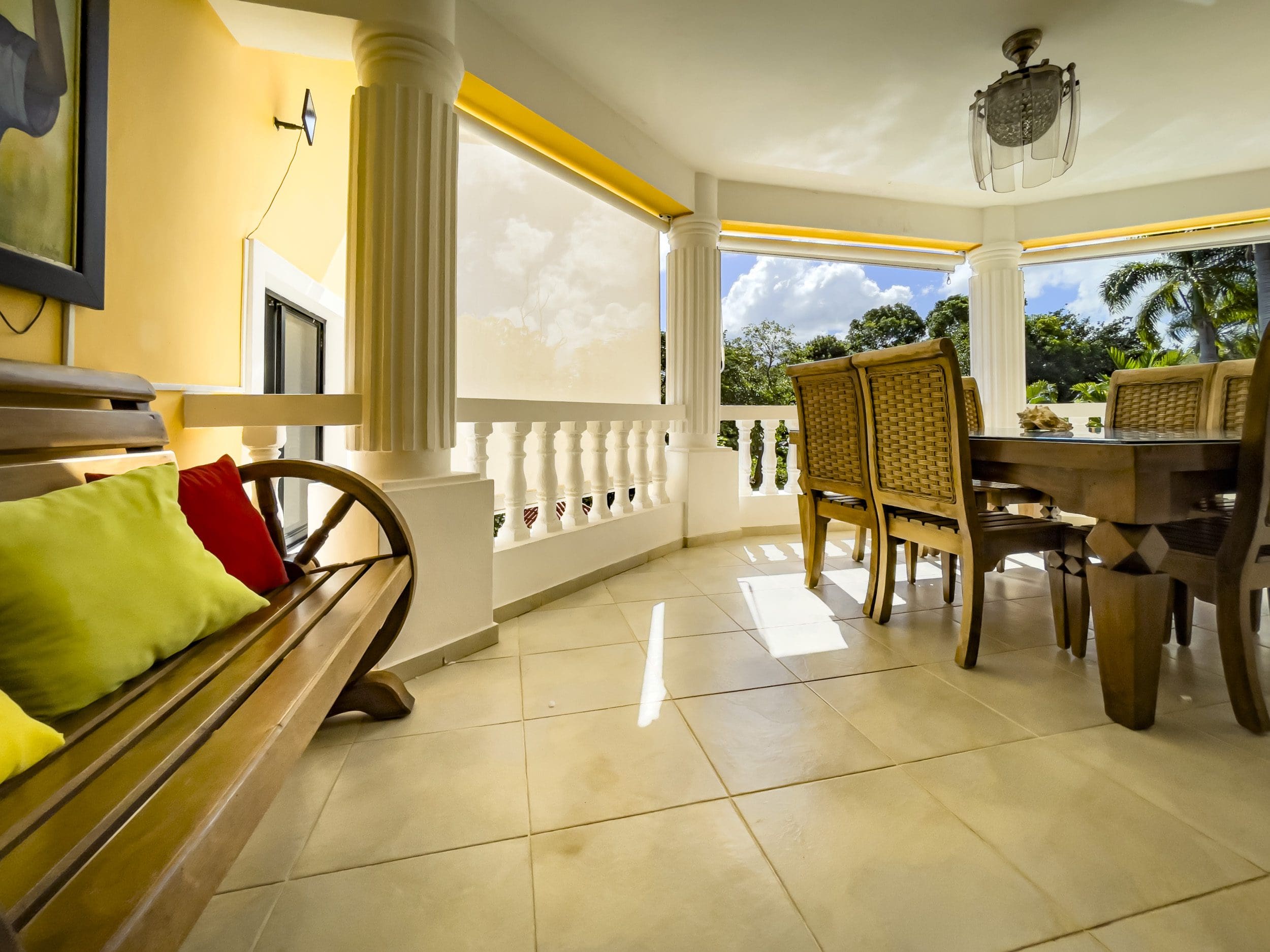 buyDRproperty Stunning 4 Bedroom Villa: Outdoor dining area with wooden table and chairs overlooking lush greenery. Sosua Real Estate
