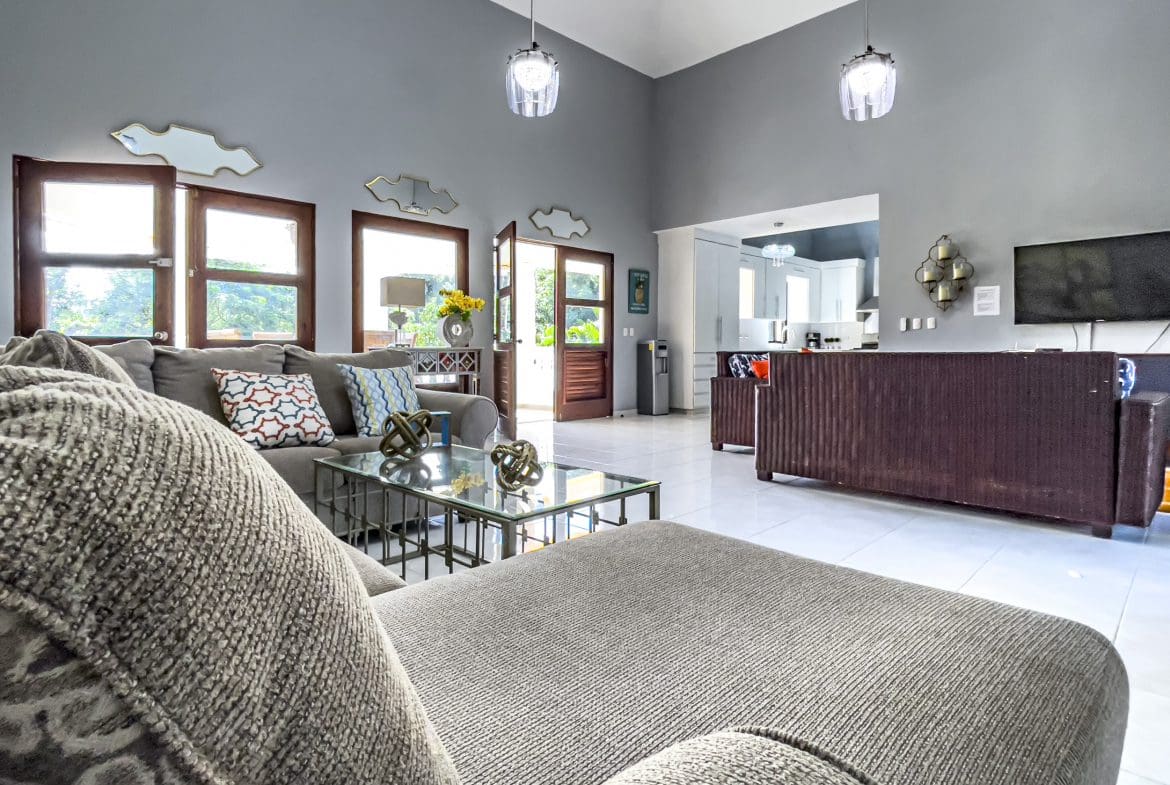buyDRproperty Living room of a stunning 4 bedroom villa with a large sofa and glass coffee table Sosua Real Estate