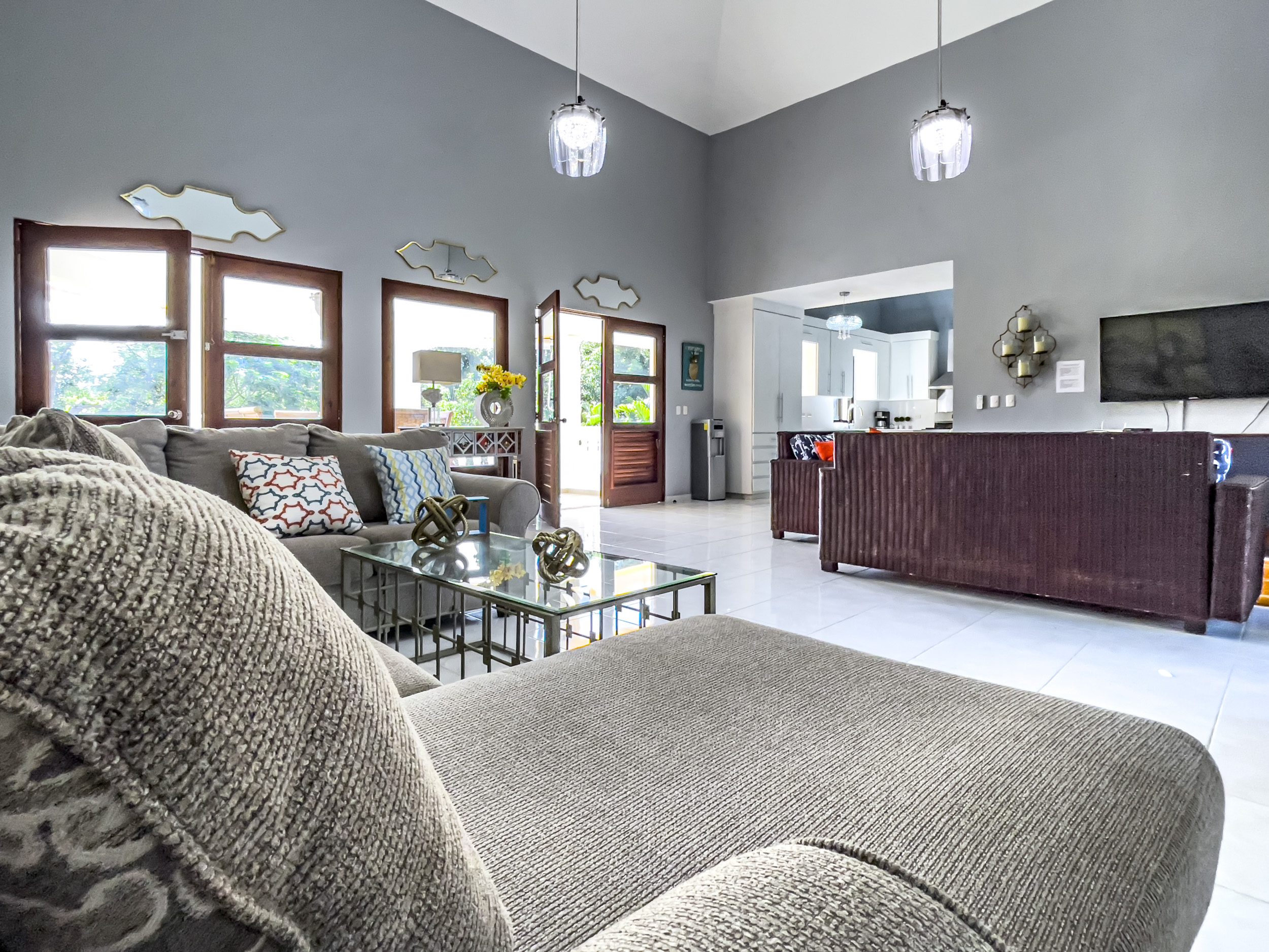 buyDRproperty Living room of a stunning 4 bedroom villa with a large sofa and glass coffee table Sosua Real Estate