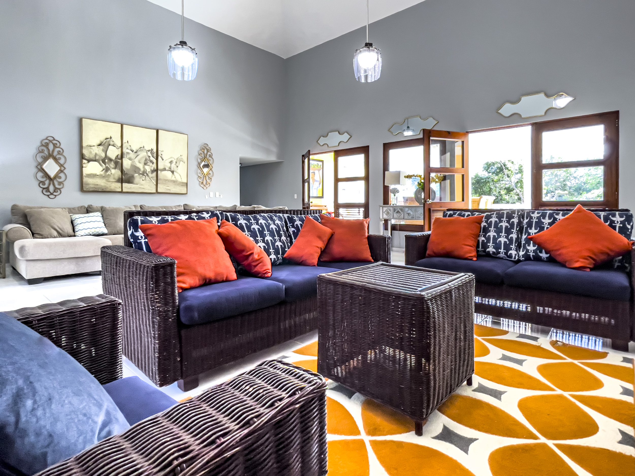 buyDRproperty Living room of a stunning 4 bedroom villa with wicker furniture and orange accents. Sosua Real Estate