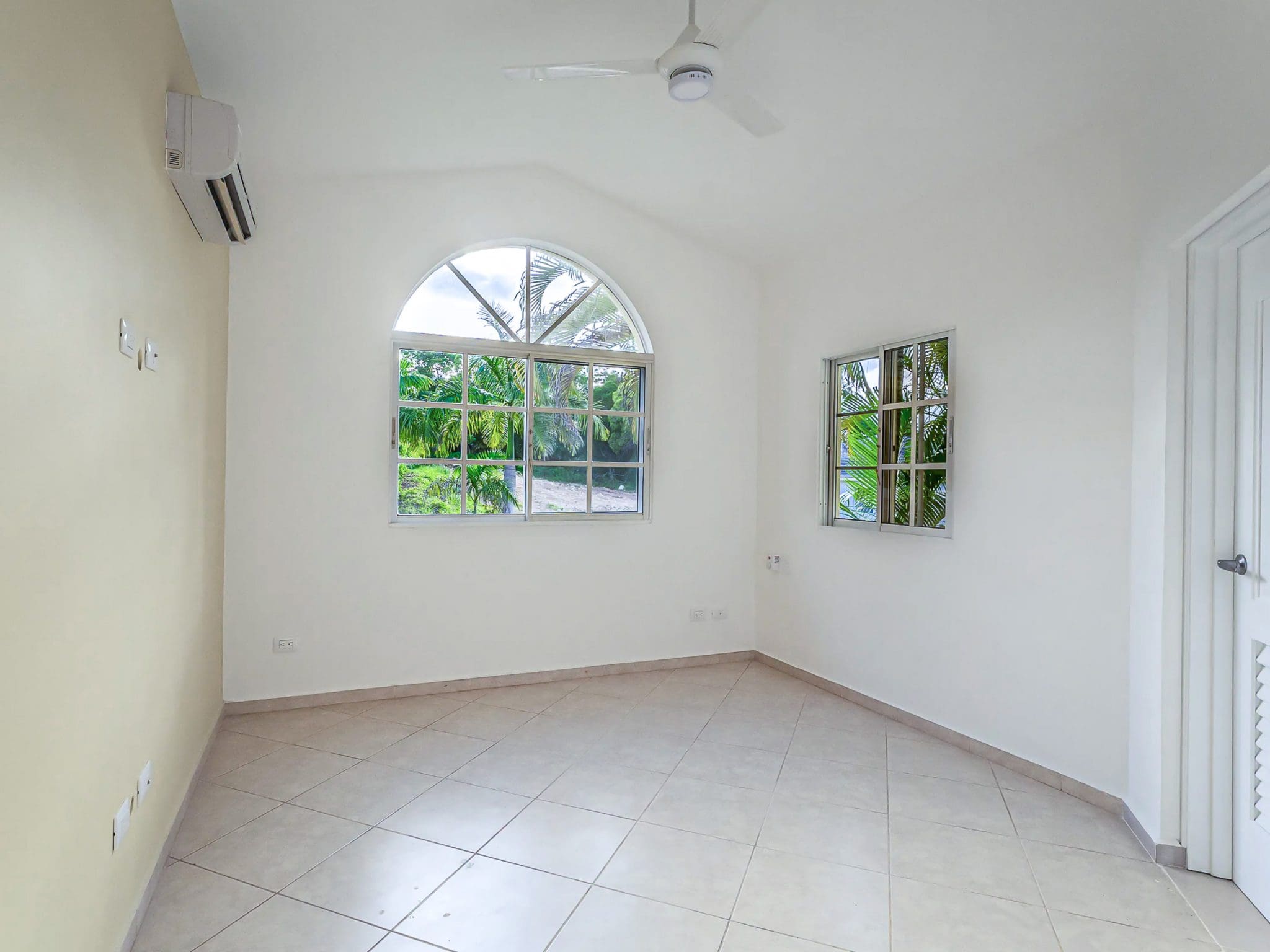 buyDRproperty Bright, empty room with arched window, part of the Renovated Villa CAOBA in Residencial Hispaniola. Sosua Real Estate