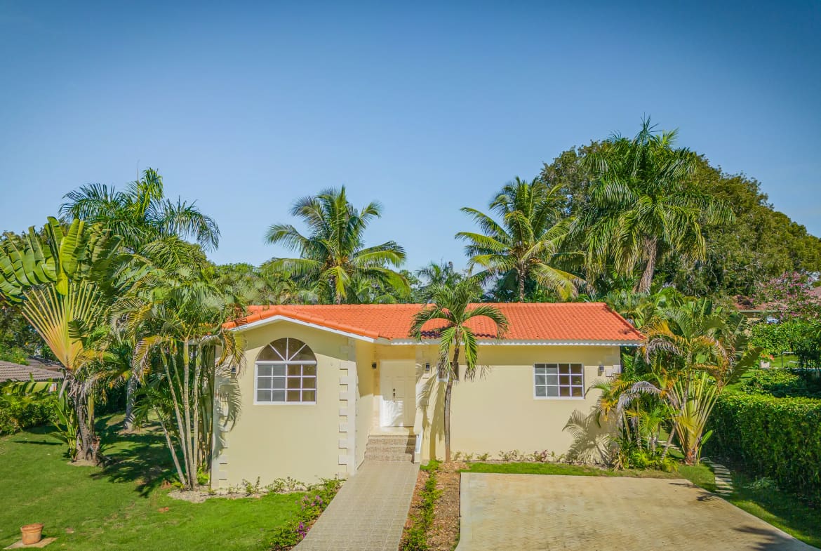 buyDRproperty Renovated Villa CAOBA in Residencial Hispaniola with lush tropical landscaping and red tile roof. Sosua Real Estate