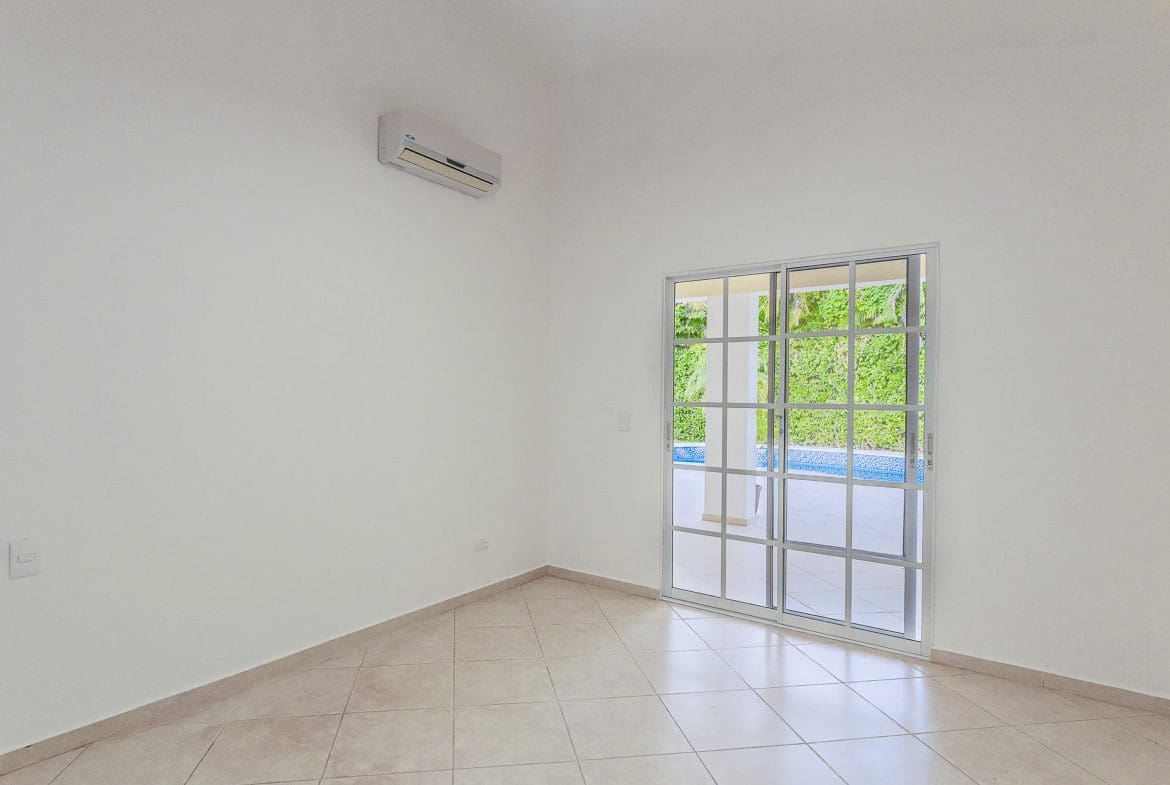 buyDRproperty Bright, empty room in a Renovated Villa CAOBA with sliding glass doors to a lush green view. Sosua Real Estate